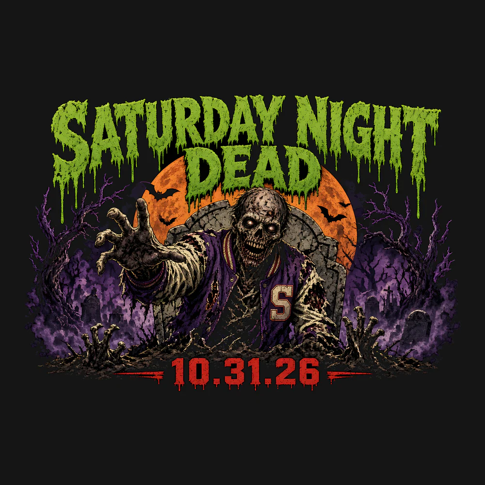 Saturday Night Dead 10.31.26 Tee: Full harvest moon with a black graveyard silhouette (dead tree, tombstones, two zombie hands) cut into it, purple bats, stacked type: SATURDAY (Anton, bone), NIGHT DEAD (